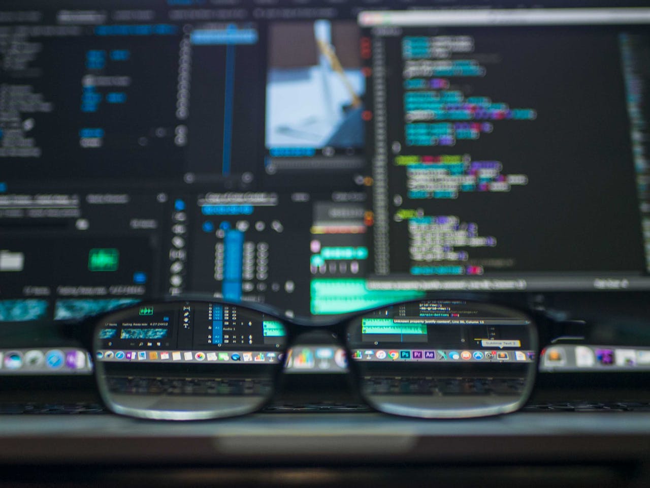 gallery-03 Eyeglasses reflecting computer code on a monitor, ideal for technology and programming themes.