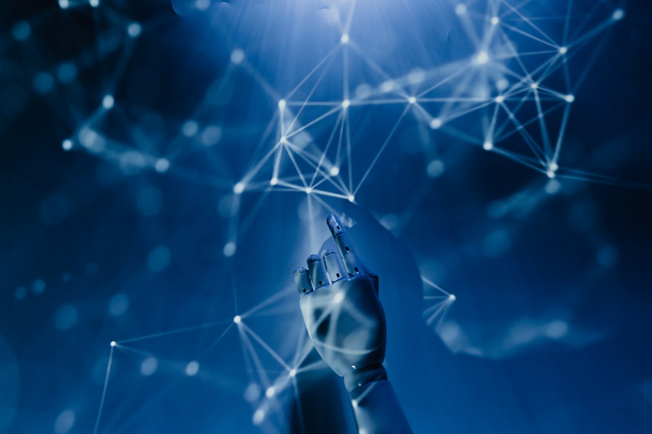 portfolio-02 A robotic hand reaching into a digital network on a blue background, symbolizing AI technology.